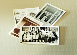 A picture of four old black and white photographs on a light brown background
