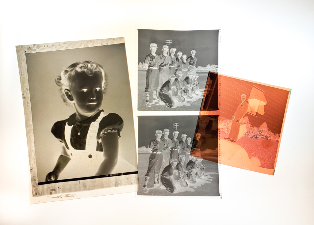 A photograph of four photographic negatives illuminated by a light table